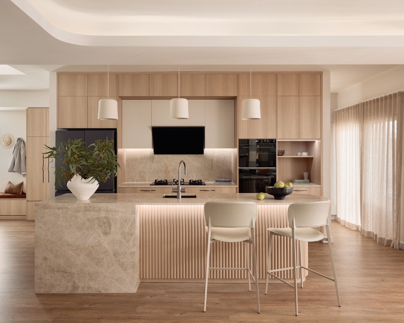 Light coloured kitchen with curved island bench.