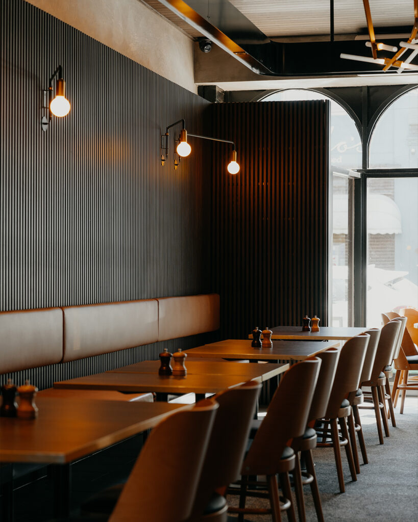 restaurant with chairs and tables with dark paneling.